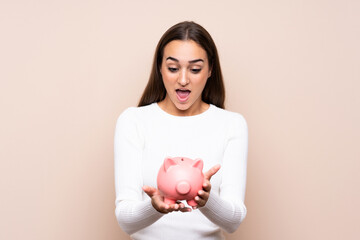 Fototapeta na wymiar Young woman over isolated background holding a big piggybank