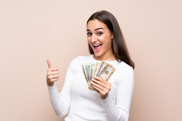 Young woman over isolated background taking a lot of money