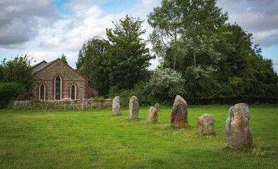 Impressive standing stones from the historic circle in Avebury Wiltshire. Sheep can be seen grazing amongst the massive rocks.