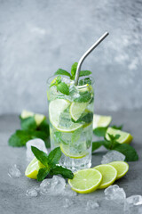 mojito cocktail with mint, lime and ice in a tall glass