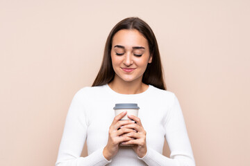 Naklejka premium Young woman over isolated background holding coffee to take away
