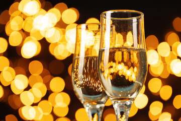 Two glasses of Champagne against bokeh lights background