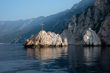 Mountain view of the island in the sea with a wooden cross near Mount Athos, Greece