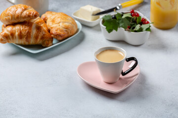 Cup of coffee and croissants on concrete background. French breakfast.