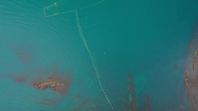 Drone flight above fishing nets in the sea water near the southern coast of the Black Sea, Bulgaria. Aerial drone view.