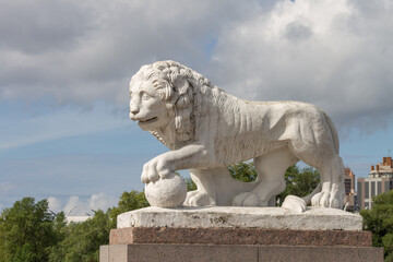 sculpture of a white lion with a ball