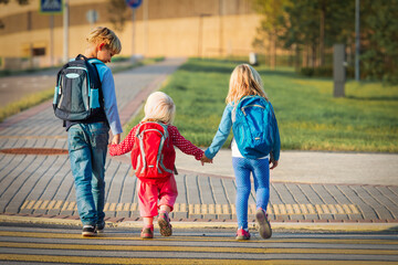 kids holding hands while going to school