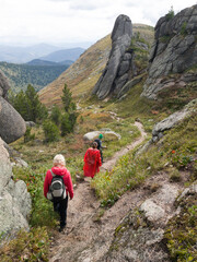 A group of travelers is walking through a beautiful mountain area. Hiking light with light backpacks. Siberia