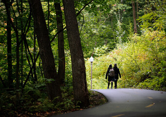 une m&egrave;re et sa fille marchent dans un parc pour aller &agrave; l'&eacute;cole
