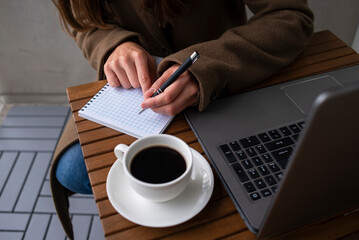 Woman working in street cafe with laptop