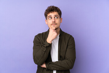 Caucasian man isolated on purple background having doubts and thinking
