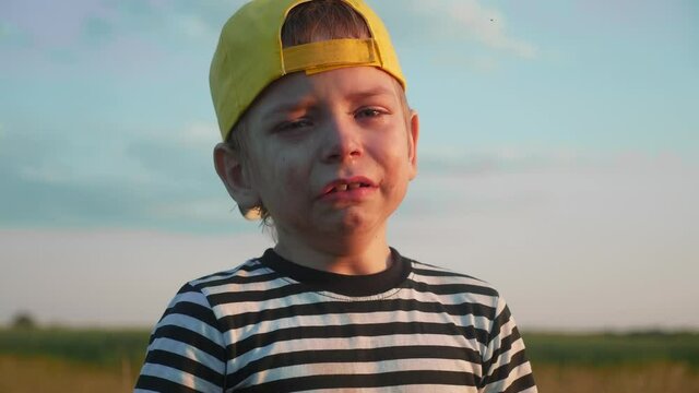 boy kid crying flowing tears a screaming dirty face. child son scream disappointed cranky lifestyle. domestic violence concept. close-up toddler roared all in tears