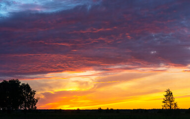 Obraz premium bright sunset over a field and a river in siberia