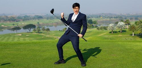 Young Asian CEO Businessman wearing suite playing golf at the golf course. Portrait of Asian businessman joying to success