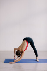 Young beautiful yoga woman is posing in studio.
