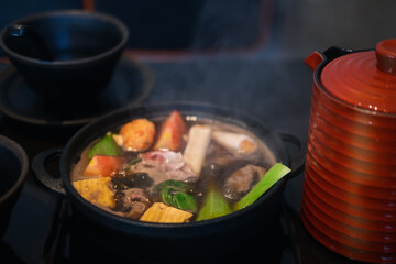 Japanese Sukiyaki with black soup in traditional cast iron pot