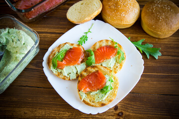 sandwich with fried bun, cheese spread and red fish in a plate