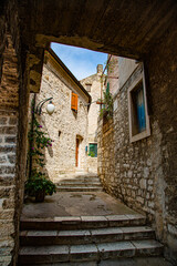 Calle estrecha con escaleras y fachadas con ventanas y puertas de madera