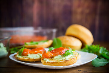 sandwich with fried bun, cheese spread and red fish in a plate