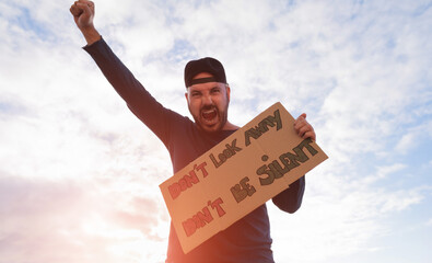 Young man with banner and strong emotions facial expressions and gestures - Man protests about the...