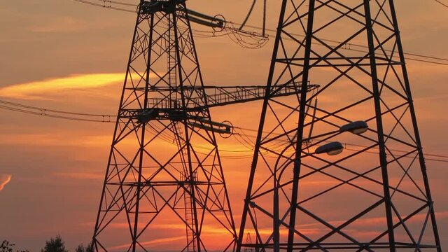 High-voltage power  line reliance at sunset