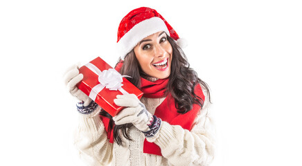 Female in Christmas winter clothes holds a red present and smiles enthusiastically at the camera