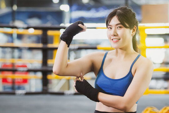 Cheerful Asian Woman Catching On Her Fat Arm With Copyspace. Young Fat Woman Trying To Exercise For Better Health. Cardio Workout And Muscle Training. Confident Sportswoman Pose For Photography.