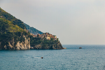 Fototapeta na wymiar Lovely panoramic landscape view of Manarola, the second-smallest of the famous Cinque Terre towns. The small town with its colourful houses and vineyards on the cliff is a popular tourist attraction.