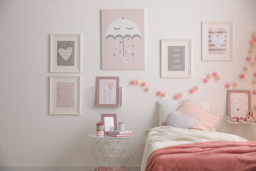 Stylish child's room interior with beautiful pictures and comfortable bed