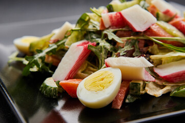Crab stick salad with fresh vegetable and eggs.
