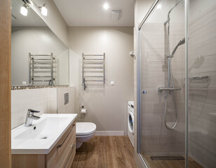 Contemporary interior in light tones of modern bathroom. Shower cabin. Sink and mirror. WC toilet.