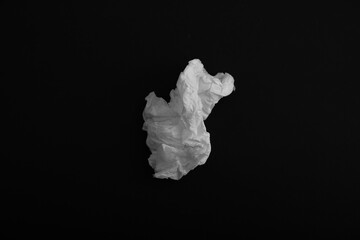 Used paper tissue on black background, top view