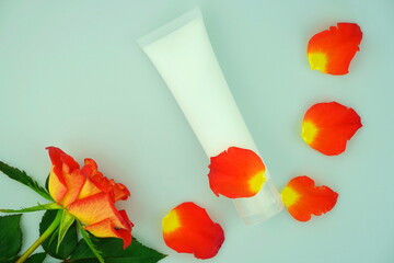 Skincare cream in white  tubes  on a blue background. Flower for decorations. Natural organic spa cosmetics concept. Top view with copy space.