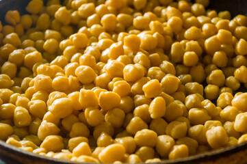 Cooking chickpeas with spices in a pan, close-up