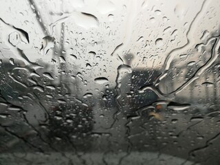 Road view through car window with rain drops, Driving in rain.