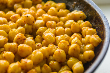 Cooking chickpeas with spices in a pan, close-up