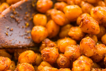 Cooking chickpeas with spices in a pan, close-up