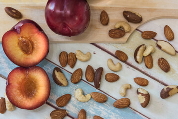 plums and nuts on a wooden table