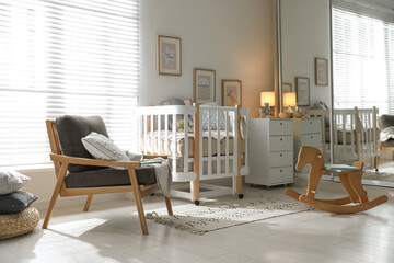 Baby room interior with crib, rocking horse and armchair