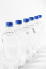 Plastic bottles with pure water on white background, closeup