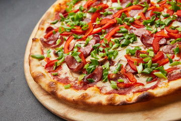 Pizza with a large number of toppings: hunting sausages, onions, cheese and bell pepper