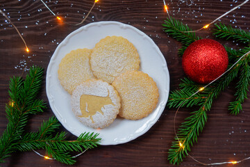 Festive Christmas layout with cookies, spruce branch and decorations. Shortbread with a silhouette of a bull close-up.