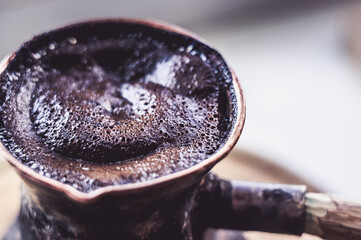 Natural coffee with thick foam, brewed in a copper cezve in the classical way, on a wooden...