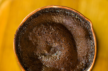Natural coffee with thick foam, brewed in a copper cezve in the classical way, on a wooden...