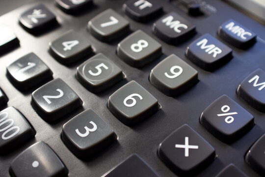 Close-up top view of the black calculator button.