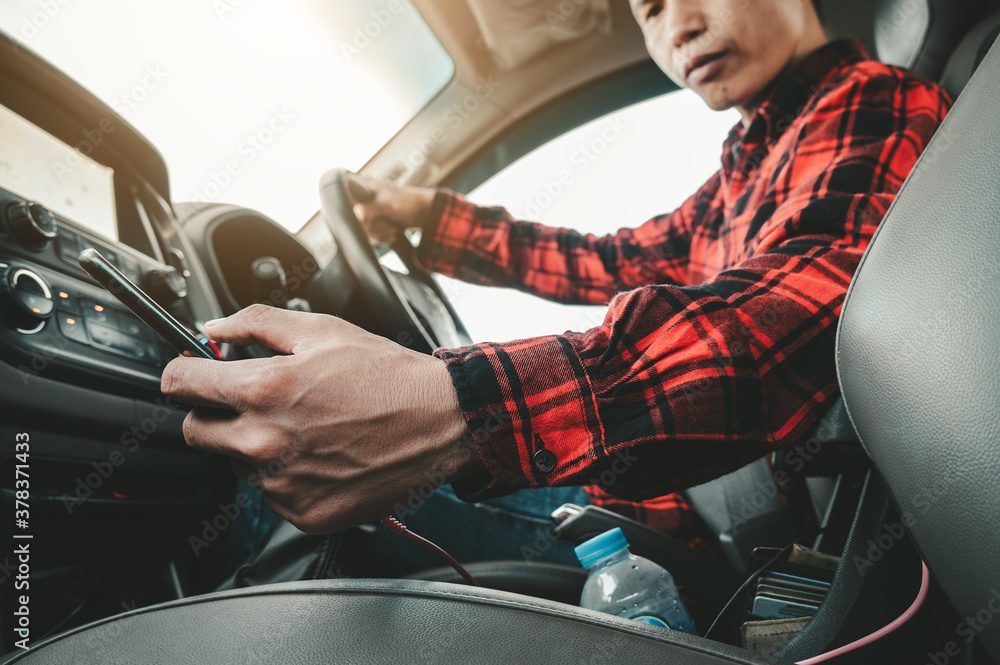 Poster driving while holding a mobile phone man looking at mobile phone while driving a car his bend down t