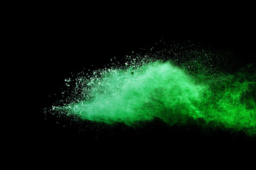 Green powder explosion on black background.