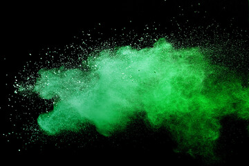 Green powder explosion on black background.