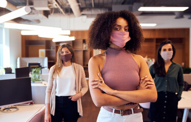 Portrait Of Female Business Team Wearing Face Masks In Open Plan Office During Covid-19 Pandemic