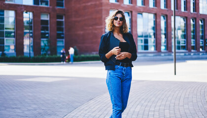 Confident woman with notepad standing on street